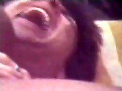 A black girl in a bikini is laying on a stretcher. A white guy pulls...
